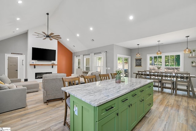 100 Grandview Dr, Anderson, SC 29625 - kitchen with green cabinetry, a breakfast bar, a kitchen island, light wood-style flooring, and high vaulted ceiling