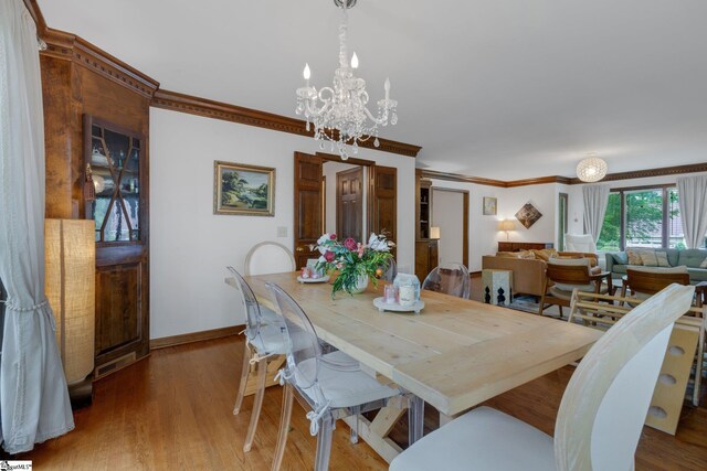 304 Oak Brook Way, Taylors, SC 29687 - dining space featuring a chandelier, ornamental molding, baseboards, and wood finished floors