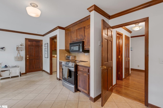 304 Oak Brook Way, Taylors, SC 29687 - kitchen featuring stainless steel electric range, black microwave, washer / clothes dryer, ornamental molding, and baseboards