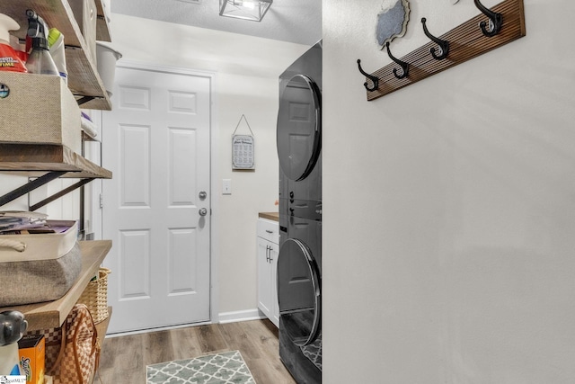 137 Mediterranean Ave, Anderson, SC 29621 - washroom featuring cabinet space, stacked washing machine and dryer, light wood-style floors, and baseboards