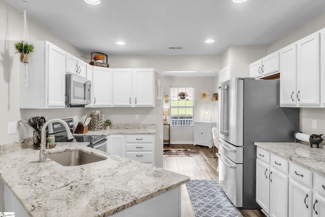 137 Mediterranean Ave, Anderson, SC 29621 - kitchen with appliances with stainless steel finishes, dark wood-type flooring, a sink, white cabinets, and light stone countertops