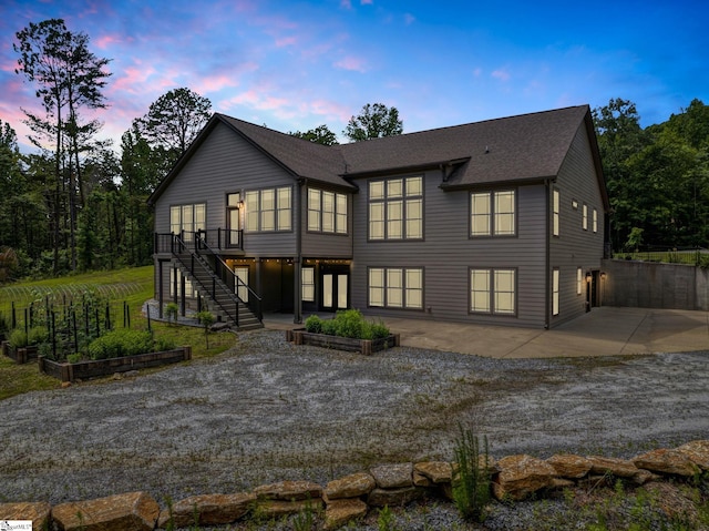 1061 Hidden Glory Dr, Landrum, SC 29356 - back of property at dusk with a patio, a garden, stairway, and a deck