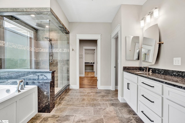 1061 Hidden Glory Dr, Landrum, SC 29356 - bathroom featuring a shower stall, vanity, a walk in closet, a bath, and baseboards