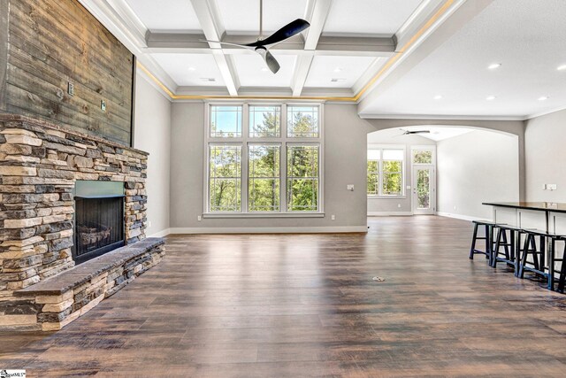 1061 Hidden Glory Dr, Landrum, SC 29356 - unfurnished living room with ceiling fan, arched walkways, a fireplace, crown molding, and beam ceiling