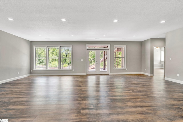1061 Hidden Glory Dr, Landrum, SC 29356 - unfurnished living room with healthy amount of natural light, dark wood-style flooring, a textured ceiling, baseboards, and recessed lighting