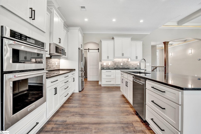 1061 Hidden Glory Dr, Landrum, SC 29356 - kitchen featuring appliances with stainless steel finishes, a sink, decorative columns, crown molding, and arched walkways