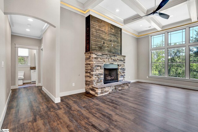 1061 Hidden Glory Dr, Landrum, SC 29356 - unfurnished living room featuring crown molding, a ceiling fan, arched walkways, a fireplace, and wood finished floors