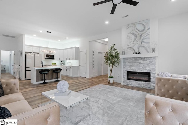 223 R C Thompson Rd, Chesnee, SC 29323 - living area with light wood-type flooring, a ceiling fan, a stone fireplace, recessed lighting, and baseboards