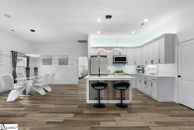223 R C Thompson Rd, Chesnee, SC 29323 - kitchen with white refrigerator, stainless steel microwave, wood finished floors, tasteful backsplash, and recessed lighting