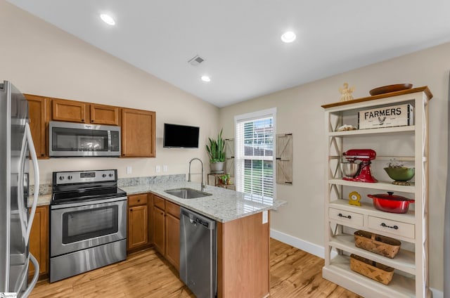 7 Slate Ln, Greer, SC 29650 - kitchen with appliances with stainless steel finishes, a sink, brown cabinets, a peninsula, and lofted ceiling