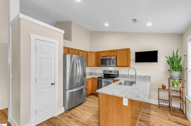 7 Slate Ln, Greer, SC 29650 - kitchen featuring appliances with stainless steel finishes, a sink, a peninsula, brown cabinetry, and light wood finished floors