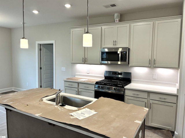 213 Fenner Pl, Greenville, SC 29607 - kitchen with stainless steel microwave, black gas range, a sink, pendant lighting, and light countertops