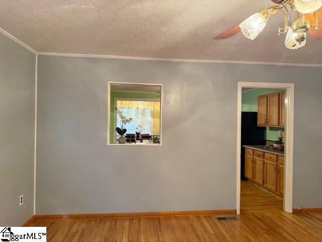 3444 Geer Hwy, Marietta, SC 29661 - unfurnished room featuring crown molding, a textured ceiling, light wood-style flooring, and baseboards