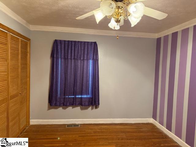 3444 Geer Hwy, Marietta, SC 29661 - unfurnished bedroom featuring wood finished floors, baseboards, ornamental molding, a closet, and ceiling fan