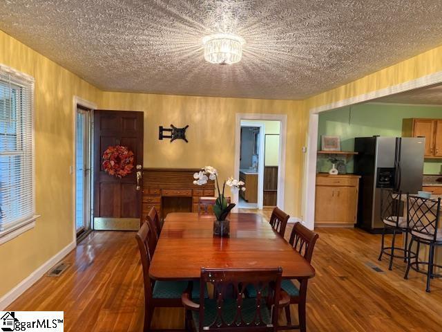 3444 Geer Hwy, Marietta, SC 29661 - dining space featuring a textured ceiling, wood finished floors, baseboards, healthy amount of natural light, and wooden walls