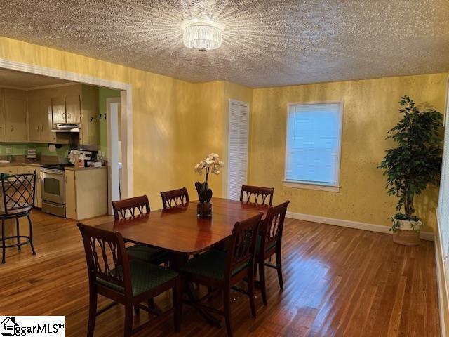 3444 Geer Hwy, Marietta, SC 29661 - dining room with wood finished floors, baseboards, a textured ceiling, and a chandelier