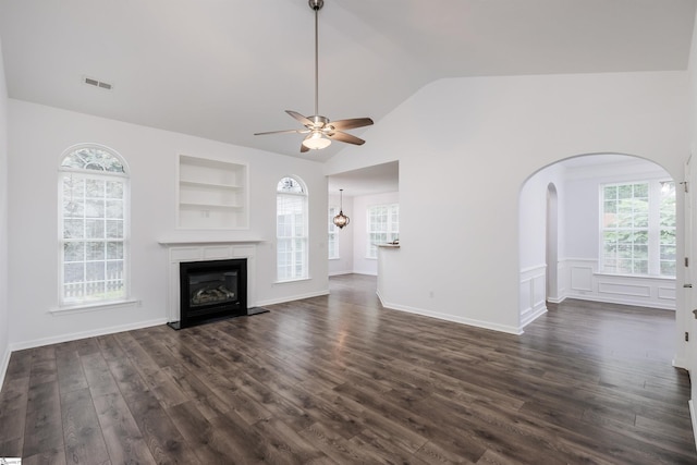16 Glenbow Ct, Simpsonville, SC 29680 - unfurnished living room featuring dark wood-type flooring, ceiling fan, arched walkways, built in shelves, and vaulted ceiling