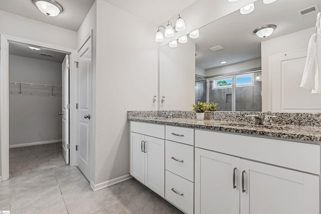 122 Rivermill Pl, Piedmont, SC 29673 - bathroom featuring double vanity, a stall shower, a walk in closet, and baseboards