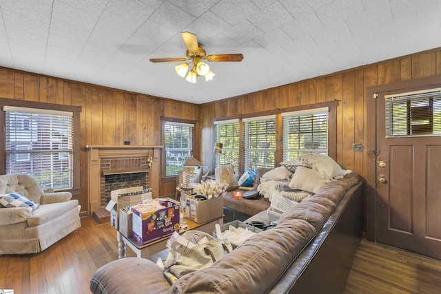 2413 Andrews Rd, Spartanburg, SC 29302 - living room featuring ceiling fan, wood walls, hardwood / wood-style flooring, and a brick fireplace