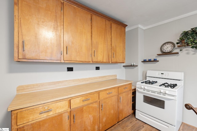 1 Baldwin St, Pelzer, SC 29669 - kitchen featuring white gas range oven, ornamental molding, light countertops, light wood-style flooring, and brown cabinetry