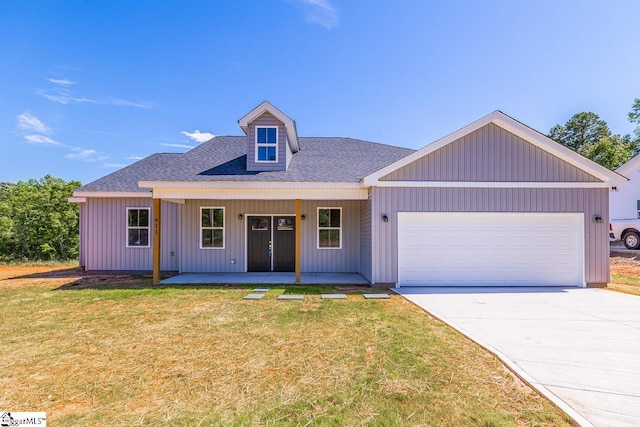 411 Wyatt Rd, Piedmont, SC 29673 - view of front of home featuring an attached garage, a shingled roof, a front lawn, concrete driveway, and board and batten siding