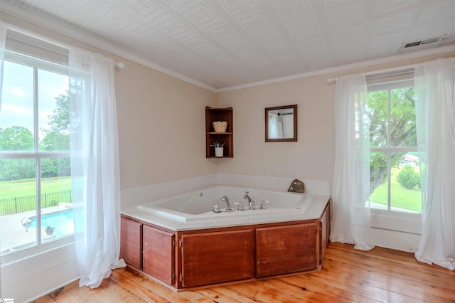 251 W Mcelhaney Rd, Taylors, SC 29687 - bathroom featuring a garden tub, hardwood / wood-style flooring, healthy amount of natural light, and ornamental molding