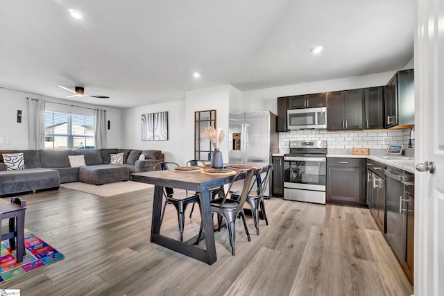 709 Bolsover Way, Woodruff, SC 29388 - kitchen with stainless steel appliances, light wood-style flooring, tasteful backsplash, open floor plan, and ceiling fan