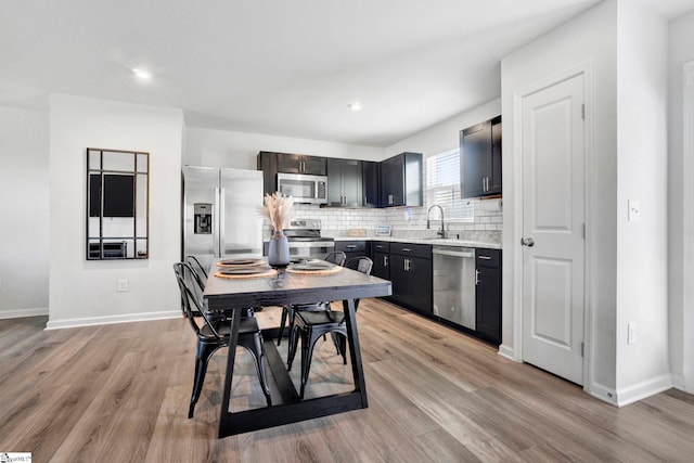 709 Bolsover Way, Woodruff, SC 29388 - kitchen with appliances with stainless steel finishes, light countertops, light wood finished floors, decorative backsplash, and baseboards