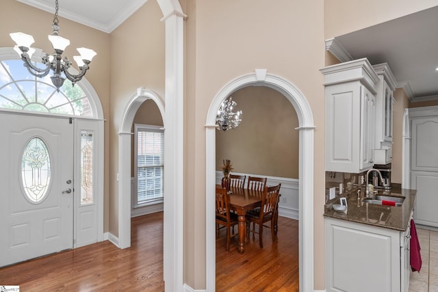 3 Swamp Lily Ct, Simpsonville, SC 29681 - entryway featuring a chandelier, arched walkways, ornamental molding, light wood-style floors, and a high ceiling