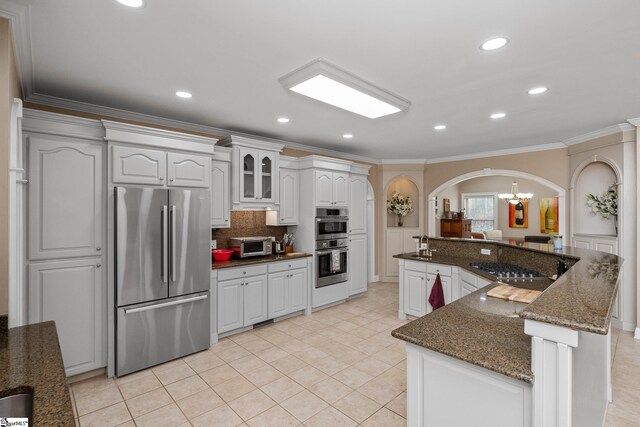 3 Swamp Lily Ct, Simpsonville, SC 29681 - kitchen with stainless steel appliances, arched walkways, crown molding, a chandelier, and backsplash