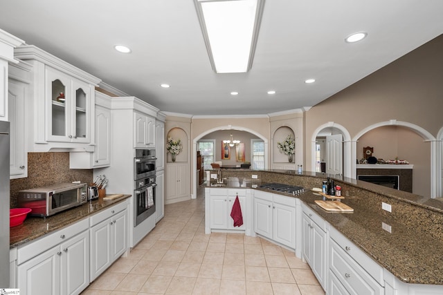 3 Swamp Lily Ct, Simpsonville, SC 29681 - kitchen featuring arched walkways, a chandelier, light tile patterned flooring, white cabinets, and appliances with stainless steel finishes