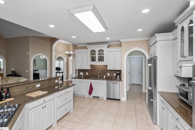 3 Swamp Lily Ct, Simpsonville, SC 29681 - kitchen with stainless steel appliances, arched walkways, ornamental molding, glass insert cabinets, and white cabinets