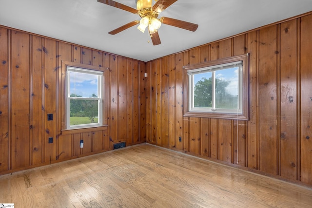 611 E S 6th St, Seneca, SC 29678 - empty room featuring light wood-type flooring, plenty of natural light, ceiling fan, and wooden walls