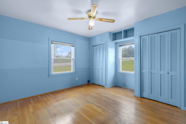 611 E S 6th St, Seneca, SC 29678 - unfurnished bedroom featuring two closets, hardwood / wood-style floors, baseboards, and ceiling fan