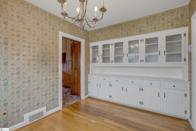 611 E S 6th St, Seneca, SC 29678 - unfurnished dining area featuring wallpapered walls, a chandelier, light wood-type flooring, and baseboards