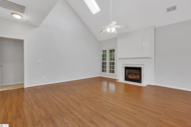 100 Beason Farm Ln, Simpsonville, SC 29681 - unfurnished living room with high vaulted ceiling, a skylight, light wood-type flooring, a fireplace, and a ceiling fan