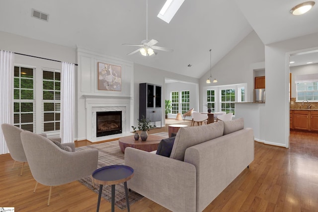 100 Beason Farm Ln, Simpsonville, SC 29681 - living area with a ceiling fan, a fireplace, high vaulted ceiling, light wood-type flooring, and a skylight