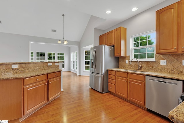 100 Beason Farm Ln, Simpsonville, SC 29681 - kitchen featuring appliances with stainless steel finishes, light wood-style flooring, a sink, decorative backsplash, and light stone countertops