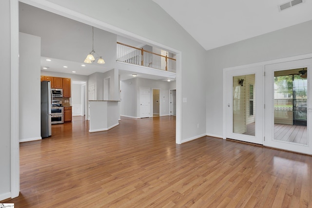 100 Beason Farm Ln, Simpsonville, SC 29681 - unfurnished living room featuring light wood-style flooring, high vaulted ceiling, baseboards, a chandelier, and recessed lighting