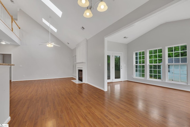 100 Beason Farm Ln, Simpsonville, SC 29681 - unfurnished living room featuring a skylight, high vaulted ceiling, wood finished floors, a fireplace with flush hearth, and a ceiling fan