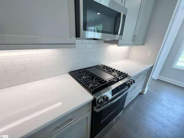 47 Hensley Rd Unit 58, Greenville, SC 29607 - kitchen featuring stainless steel appliances, tasteful backsplash, light stone countertops, dark wood-style floors, and gray cabinetry