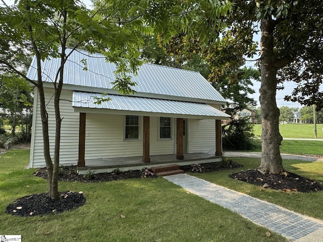 800 W Hampton St, Laurens, SC 29360 - view of front of house featuring covered porch, a front lawn, and metal roof