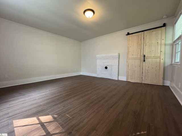 800 W Hampton St, Laurens, SC 29360 - unfurnished living room with crown molding, dark wood-style flooring, baseboards, and a barn door