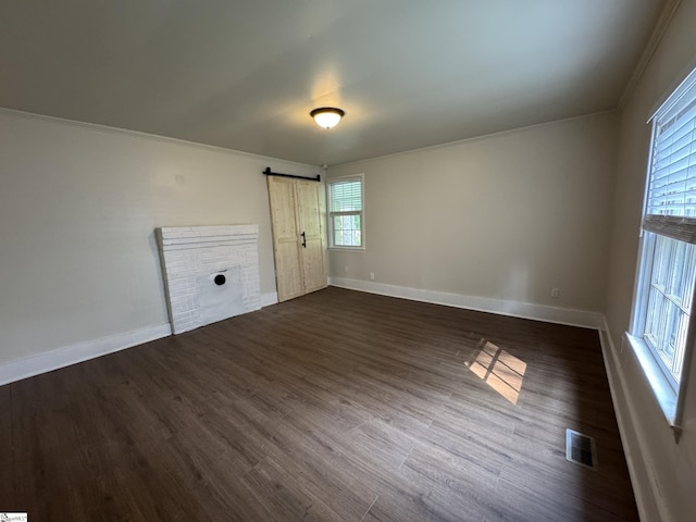 800 W Hampton St, Laurens, SC 29360 - empty room featuring a barn door, dark wood-type flooring, baseboards, and crown molding