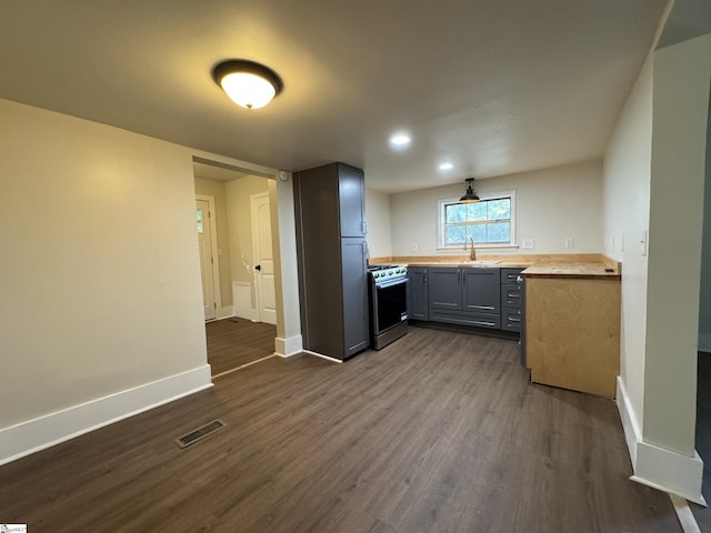 800 W Hampton St, Laurens, SC 29360 - kitchen with stainless steel gas range oven, dark wood-type flooring, gray cabinetry, baseboards, and a sink
