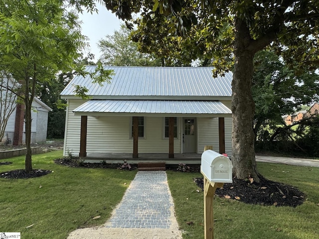 800 W Hampton St, Laurens, SC 29360 - view of front of house featuring a porch, a front yard, and metal roof