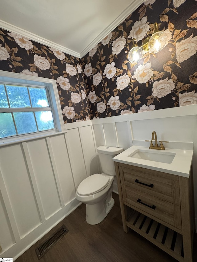 800 W Hampton St, Laurens, SC 29360 - bathroom featuring wallpapered walls, wainscoting, wood finished floors, crown molding, and toilet