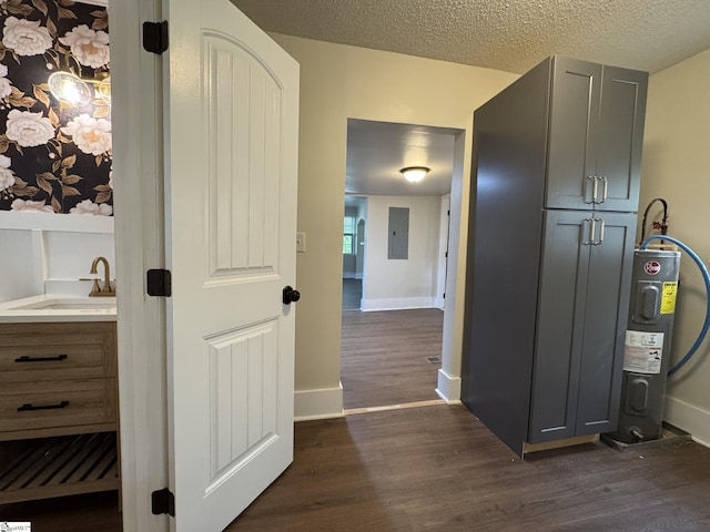800 W Hampton St, Laurens, SC 29360 - hall featuring electric water heater, dark wood finished floors, a sink, electric panel, and a textured ceiling