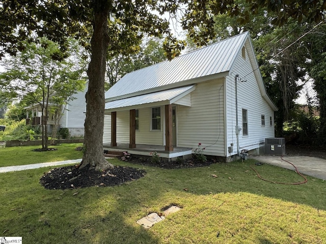 800 W Hampton St, Laurens, SC 29360 - view of front of property featuring covered porch, a front lawn, metal roof, and central air condition unit
