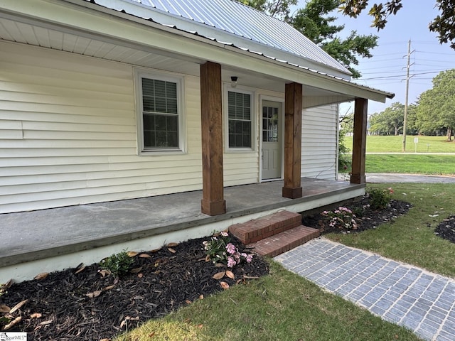 800 W Hampton St, Laurens, SC 29360 - doorway to property featuring covered porch, a yard, and metal roof